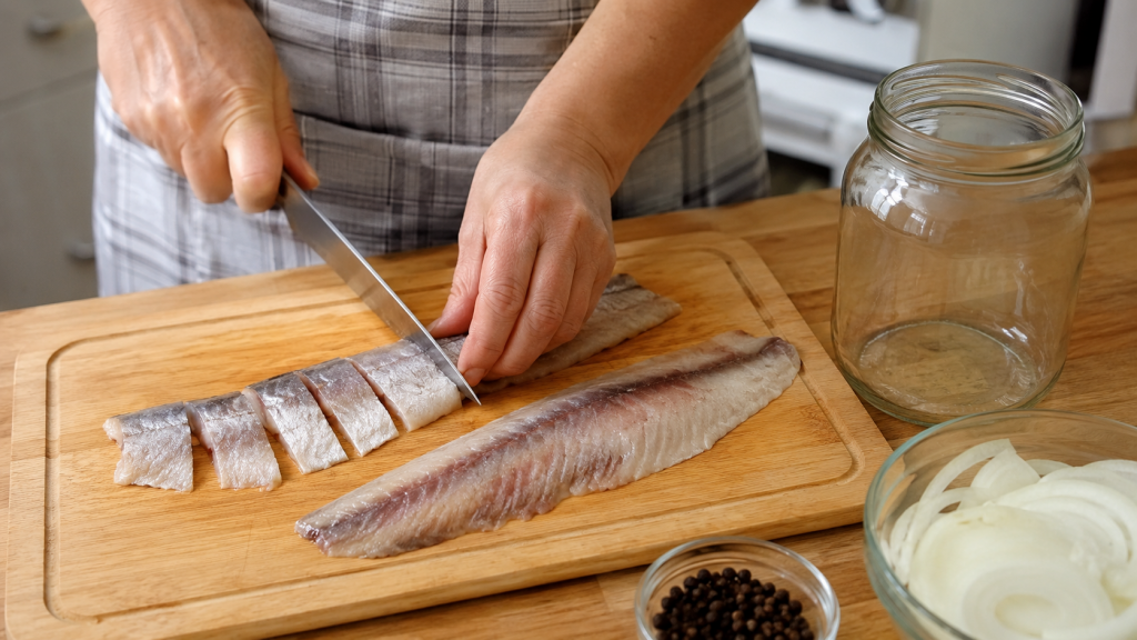 сельдь нарезают кусочками перед посолом в банке